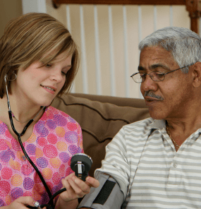 Assisted living professional taking blood pressure of patient