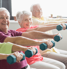 Senior residents lifting light weights in exercise class