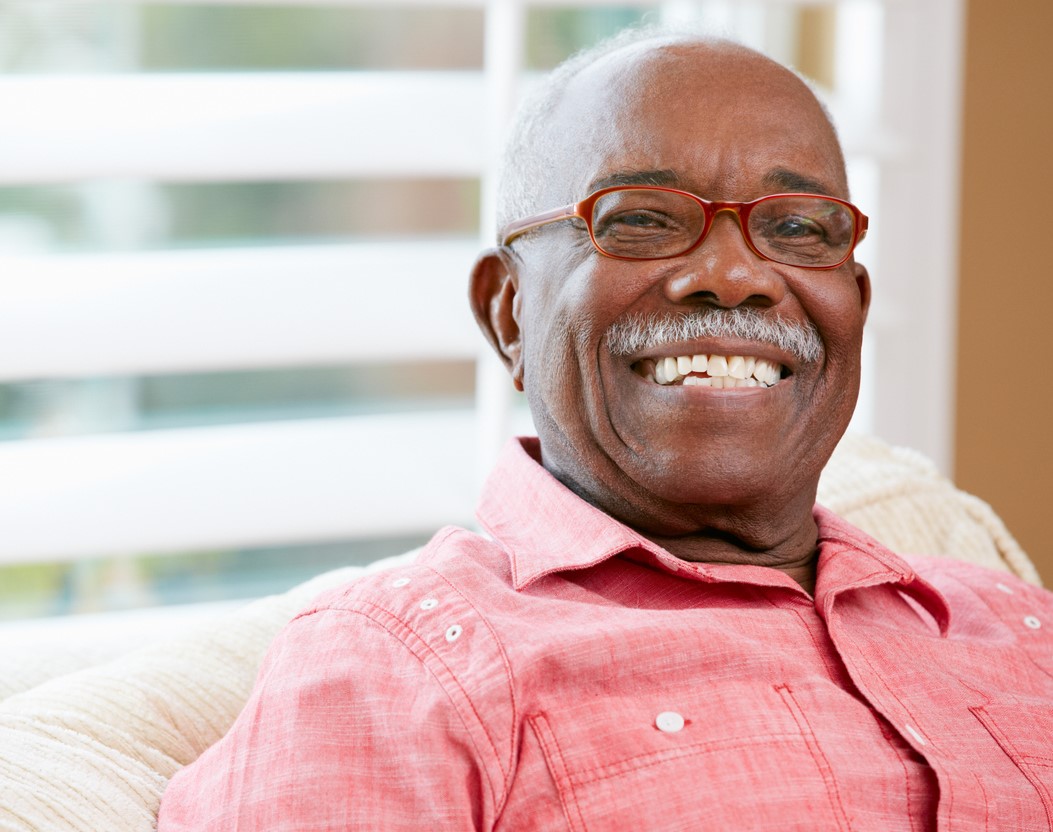 Senior man with red glasses laughing