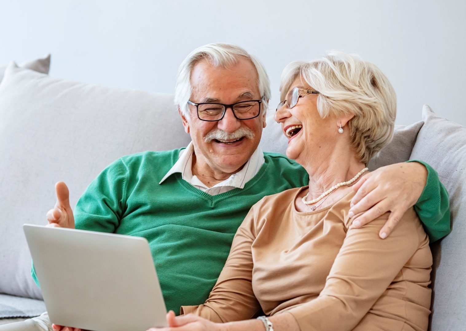 Senior couple laughing on couch